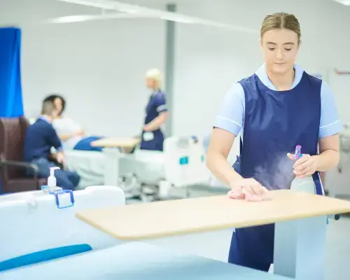 person disinfecting tables